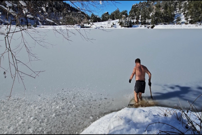 Uludağ'ın buz tutan göllerine girerek soğuk suyun keyfini çıkarıyor